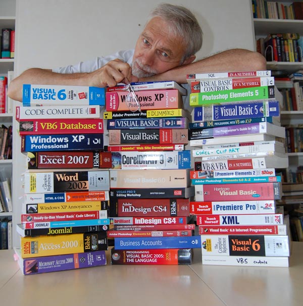 Picture of Chris Hicks and a pile of programming books used during creation of ABC accounts software.